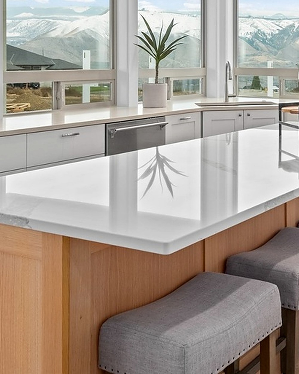 Detail of a marble waterfall kitchen island framed by mountain views