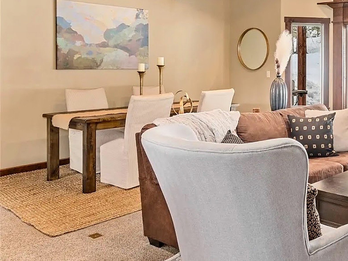 Living room seating area with a console table and abstract landscape art
