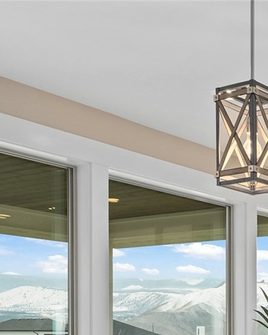 Detail of a pendant light framed by floor-to-ceiling mountain-view windows