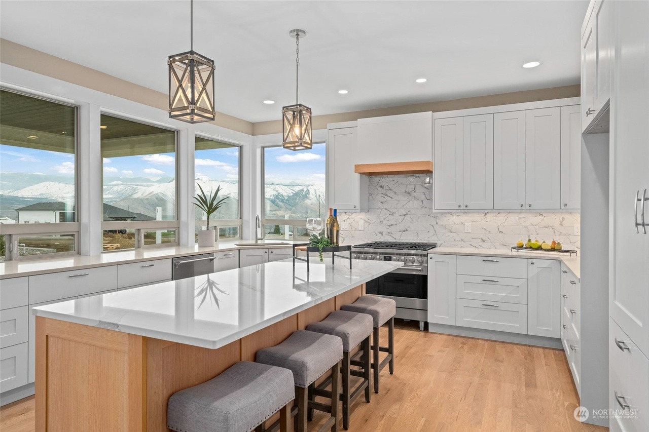 Mountain-view kitchen with a white marble waterfall island and shaker cabinetry